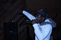 a man in a hat is singing into a microphone