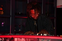 a man with dreadlocks playing a keyboard