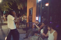 a group of people sitting on a bench at night