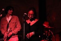 a man and a woman standing in front of a microphone