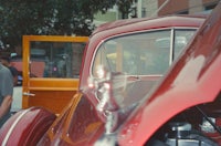 a red vintage car parked on a street