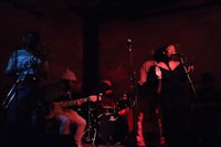 a group of people playing music in a dark room