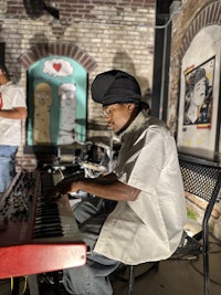a man sitting on a bench playing a keyboard