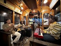 three men playing music on a trolley car